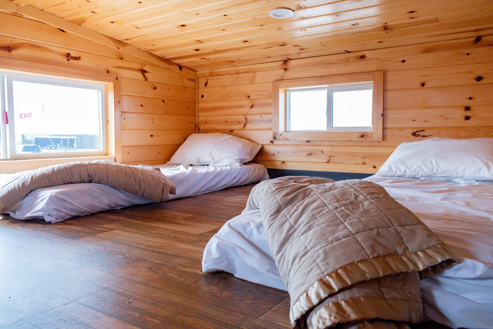 Loft sleeping area with beds in a deluxe cabin at Alta Campground