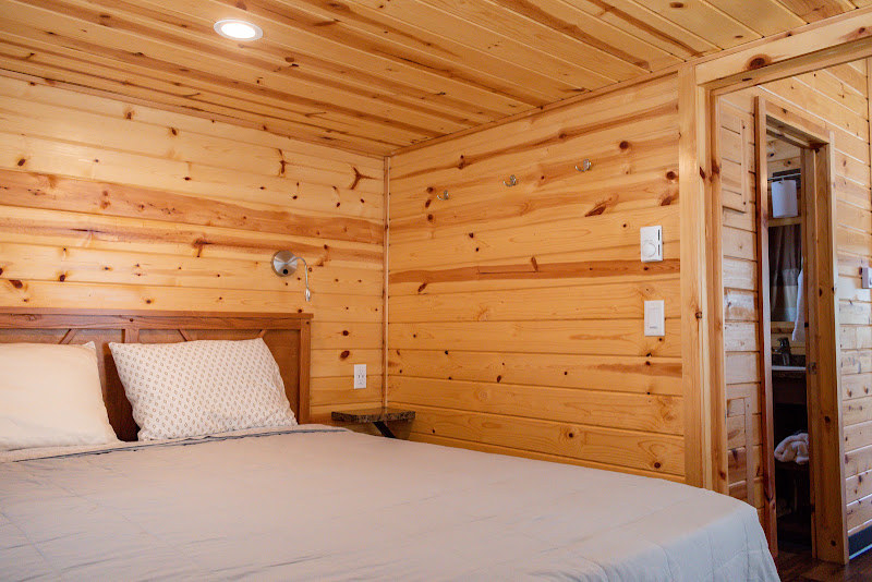 Master bedroom with queen bed and full bathroom in a deluxe cabin at Alta Campground