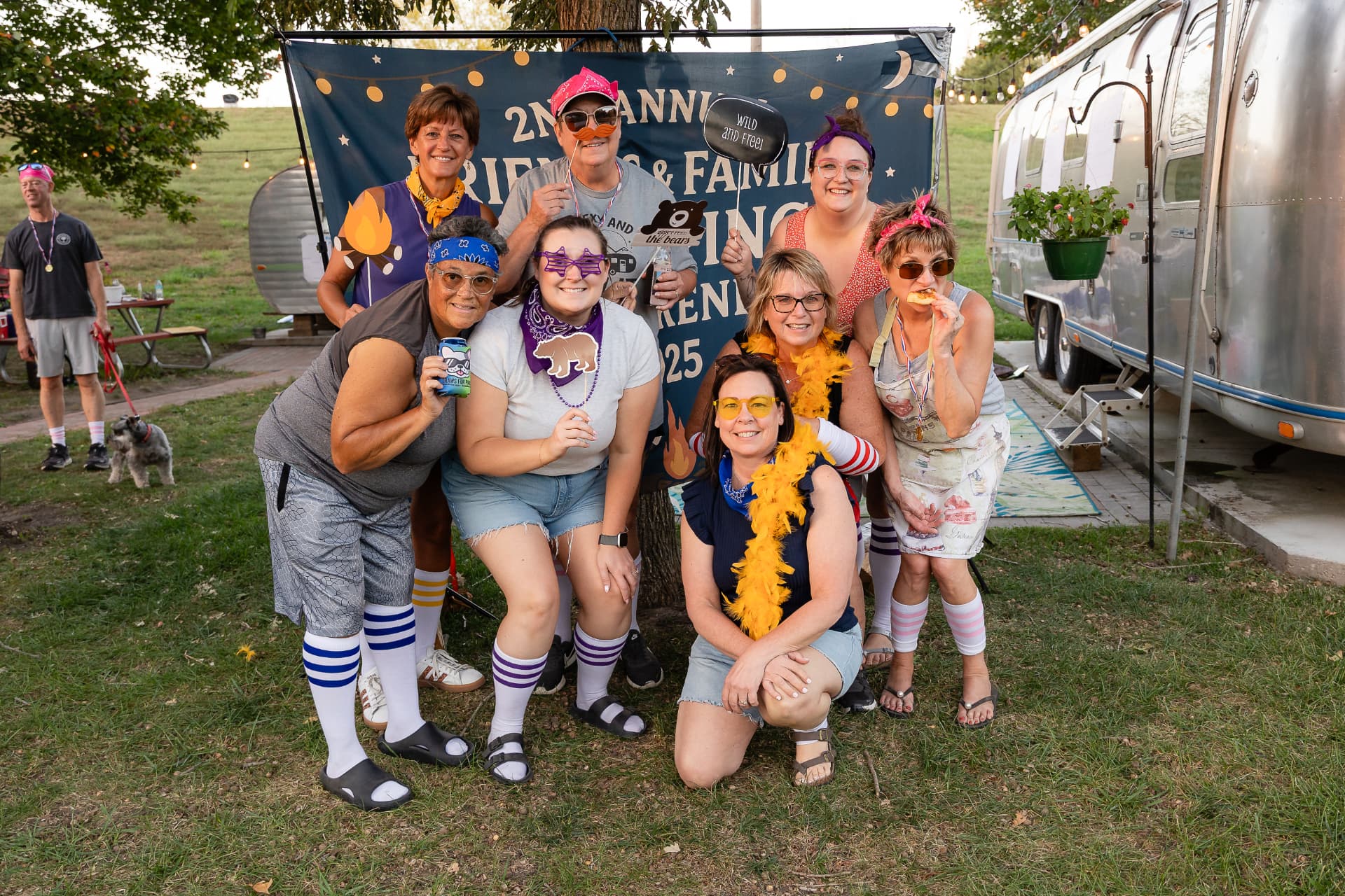 Group of guests celebrating by the vintage glamping campers